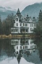 A tall gothic house at the lake shore with reflections in water