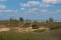 Tall grasses growing on hills of sand dunes, with some trees, in front of Lake Michigan at Kohler Dunes State Park