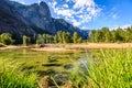 Green grass in the foreground the Merced River and some trees in front of Sentinel Rock Royalty Free Stock Photo