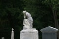 a very old tombstone headpiece statue thinking women angel carved monument marble gravestone in a shadowy graveyard cemetery