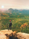 Tall hiker man with red cap, poles in hand and with big backpack stand on rock. Misty spring Royalty Free Stock Photo