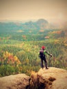 Tall hiker man with red cap, poles in hand and with big backpack stand on rock. Misty spring Royalty Free Stock Photo