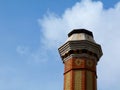 Tall industrial chimney stack of yellow and red brick of octagonal base Royalty Free Stock Photo