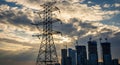 Silhouette of a High- Voltage Power Line Tower Against a Dramatic Sunset Sky with Cityscape Under Construction Royalty Free Stock Photo