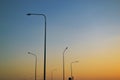 Tall lampposts against the background of a gradient evening clear sky