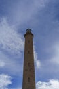 Tall lighthouse tower against blue cloudy sky Royalty Free Stock Photo