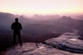 Tall man in black on cliff and watch to mountain sunrise.Silhouette in selfconfident pose Royalty Free Stock Photo