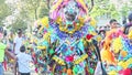 Tall man in colorific costume pose for photo on city street at dominican carnival