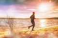 Tall man runiining alone lake. Man run on the beach Royalty Free Stock Photo