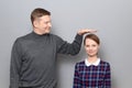 Tall man is showing height of short woman, people of different heights Royalty Free Stock Photo