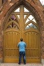 Tall man stands in front of the huge wooden doors Royalty Free Stock Photo