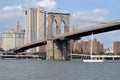 A tall-masted sailboat under the Brooklyn Bridge