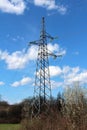 Tall metal electrical power line utility pole made of strong metal pipes with electrical wires connected with glass insulators Royalty Free Stock Photo