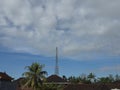 Tall metal pole surrounded by palm trees under a cloudy sky Royalty Free Stock Photo