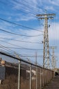 Tall metal power towers inside a chain link fence topped with barbed wire, industrial site Royalty Free Stock Photo