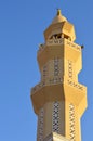 A tall minaret with golden ornament of a mosque against blue sky, minaret or tower aspiring to heaven, Islamic religion and