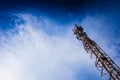 A tall modern communications tower provides telecommunications service to a city, negative space on blue background