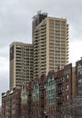 tall modern high rise low income apartment building towering above old pre-war historic apartment buildings in brooklyn Royalty Free Stock Photo