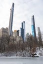 Tall Skyscrapers in the Midtown Manhattan Skyline seen from the Frozen Pond at Central Park during Winter in New York City with Sn Royalty Free Stock Photo