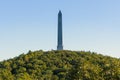 Tall obelisk monument on a mountain surrounded by vibrant forest foliage. High Point State Park, NJ