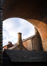 Tall old chimney pots tops under railway bridge arches on homes and houses below red brick train arch silhouetted on summer day Royalty Free Stock Photo