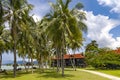 Tall palm trees and sun loungers on tropical Chenang beach on Langkawi island Royalty Free Stock Photo