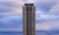 Tall residential apartment building and fluffy clouds in blue hour Royalty Free Stock Photo