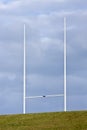 Tall rugby goal posts and blue clouds