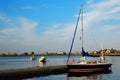 A tall sailboat is tied at a calm harbor Royalty Free Stock Photo