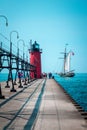 Tall ship sailing past a light house on a summer day in South Haven Michigan