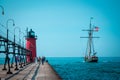 Tall ship sailing past a light house