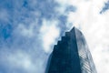 Tall skyscraper office building with cloudy blue sky