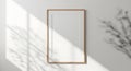 Tall rectangular mirror with warm wood frame and natural light shadows Royalty Free Stock Photo