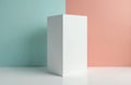 Tall, slim white rectangular box stands upright on a white surface. Clean studio setup with pastel blue and pink background Royalty Free Stock Photo