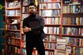 Tall smart arab student man at library