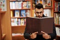 Tall smart arab student man at library