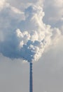 A tall smoke stack is spewing smoke into the sky Royalty Free Stock Photo