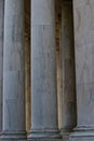 Tall smooth marble columns on stone building with light shining on them Royalty Free Stock Photo