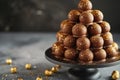 A tall stack of assorted chocolate candies arranged neatly on a round plate, A dessert tower of gold-dusted gourmet chocolate