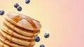 Stack of fluffy pancakes with maple syrup and powdered sugar, fresh blueberries falling Royalty Free Stock Photo