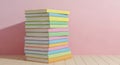 Tall stack of pastel colored sticky notes casting a shadow against a pink wall Royalty Free Stock Photo