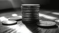 Silver coins stacked on a wooden surface illuminated by sunlight in a minimalist setting Royalty Free Stock Photo