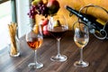 Tall stem glasses of rose, red and white wine on a wooden table Royalty Free Stock Photo