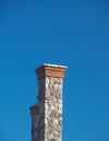 Tall stone chimney against clear deep blue sky 2