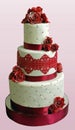 Tall three-tier wedding cake decorated with burgundy cream roses and ribbons.