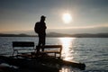 Tall tourist with backpack walk on beach at pedal boat in the sunset. Autumn at sea Royalty Free Stock Photo