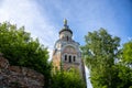 A tall tower against a blue sky, surrounded by green trees Royalty Free Stock Photo