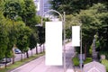 _Tall vertical hanging blank advertising banners posters mockup lush plants and tress in background for OOH out of home lamp post