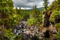 Tall vertical overlook for a small turbulent creek leading into the Rogue River in Oregon