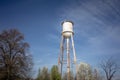 Tall water tower with cloudy blue sky background